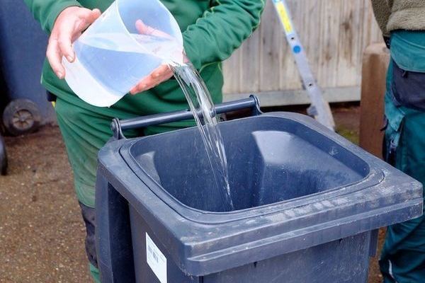 Mitarbeiter bei der Befllung der Tonne mit Wasser