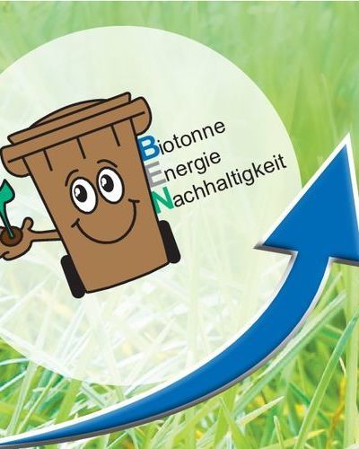 Das Bild zeigt die Grafik der Biotonne mit dem Schriftzug Biotonne, Energie, Nachhaltigkeit, auf einer grünen Wiese mit einem aufwärtszeigenden blauen Pfeil, Grafik G. Kaiser
